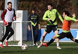 Zubeldia realizar un pase obstaculizado por Odriozola en el entrenamiento del lunes en Zubieta