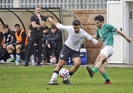 Aitor Andreano, autor del gol de la victoria en Oñati, juega el balón ante la atenta mirada del mister, Joseba Roteta y el banquillo.