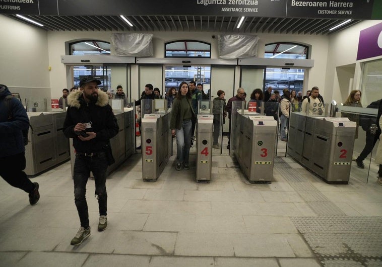 Viajeros pasan por los tornos de la estación del tren.