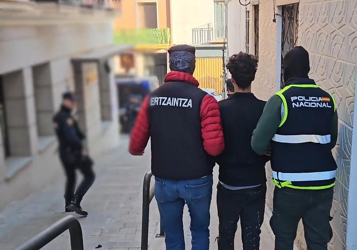Un ertzaina y un policía nacional acompañan al jovenque se habíadesplazado a un pisookupado en Madrid.