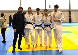 Los cuatros medallistas del Judo Club Tolosa con el entrenador Óscar Gibelalde, sobre el tatami de Urnieta.