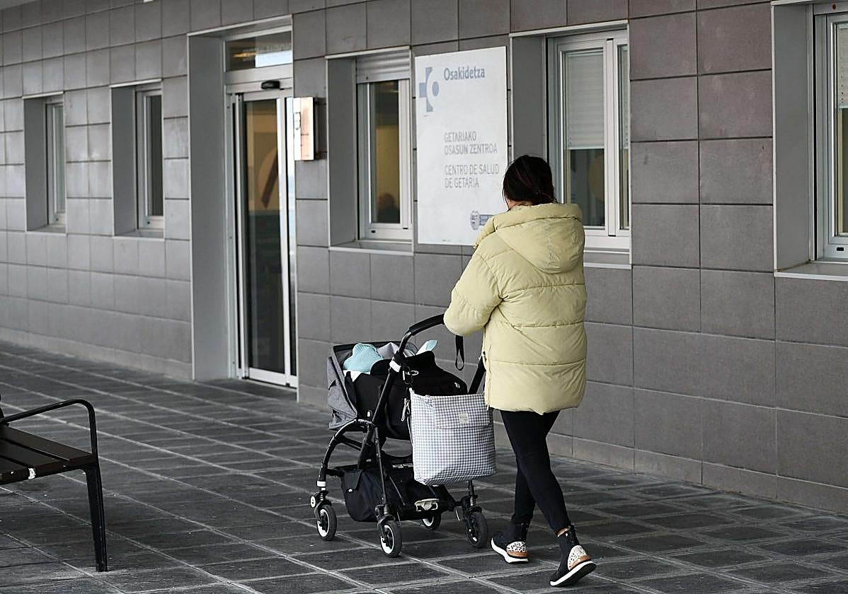 Una mujer acude con su bebé a la consulta del pediatra en el centro de salud de Getaria.