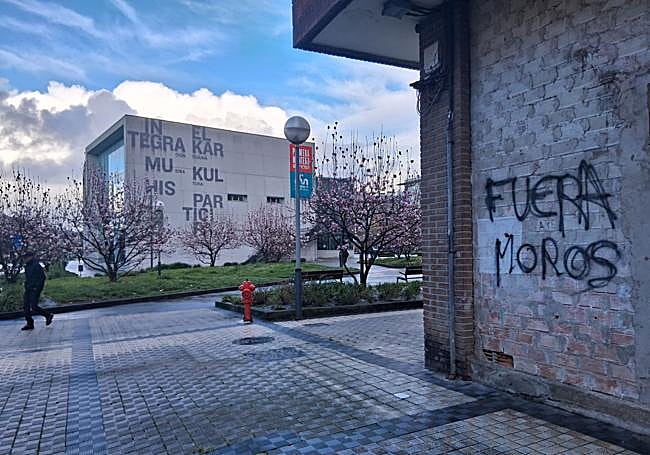Una de las pintadas que ha aparecido este martes, con el centro cívico, al fondo.