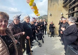 Loli García, al fondo de la imagen, izó la bandera de los jubilados sanjuandarras rodeada del resto de usuarios del centro de día.