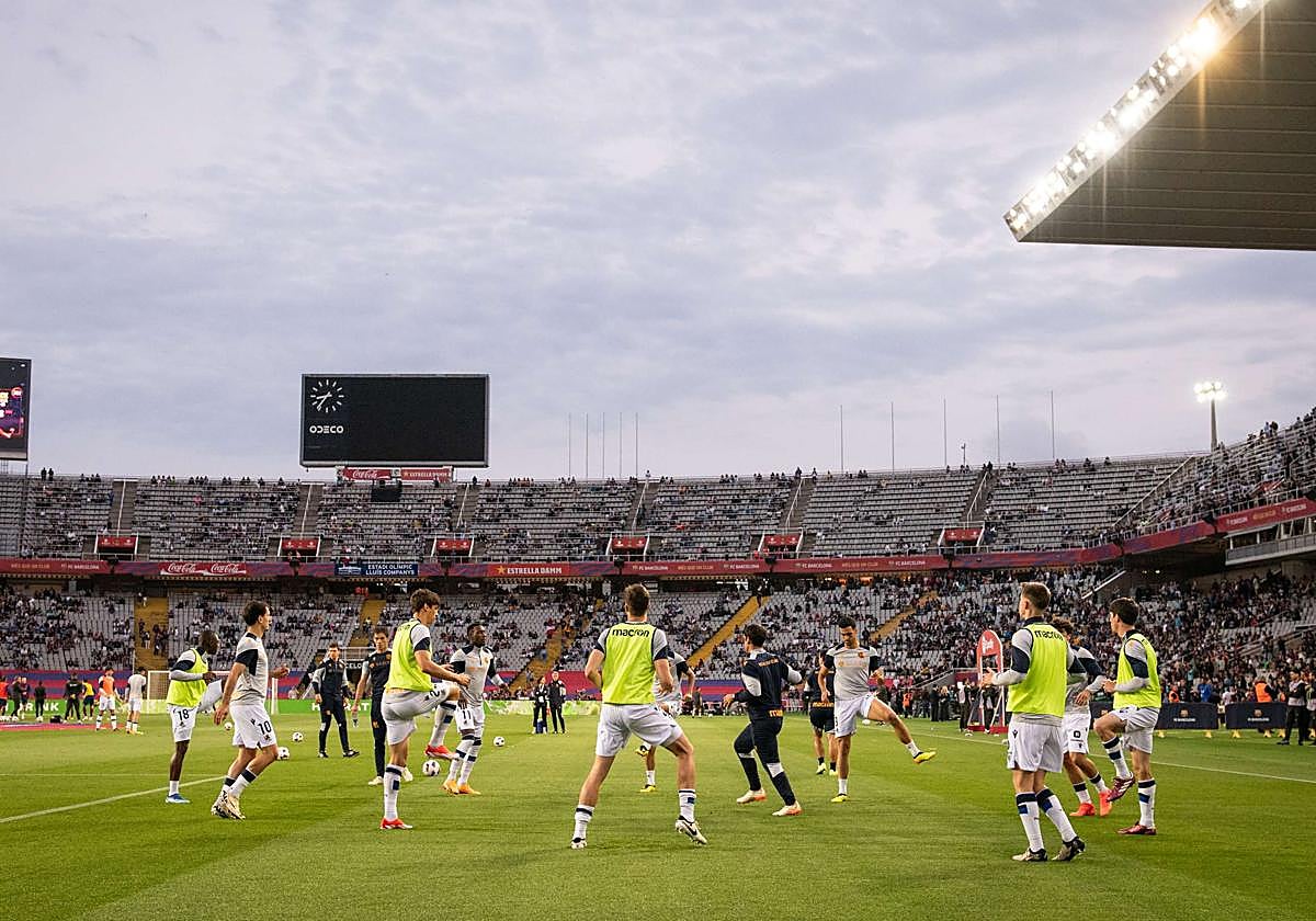 Los jugadores de la Real realizando ejercicios de calentamiento en el partido de la pasada temporada disputado en Montjuic.