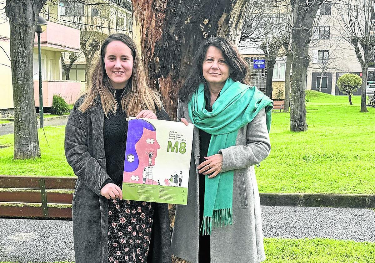 Irati Baroja, responsable del departamento de Igualdad, y la concejala de Igualdad Gloria Vázquez con el cartel del programa del 8M.