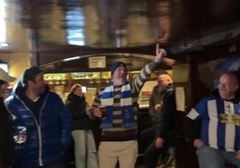 Un aficionado de la Real dirige los cánticos de ánimo en un pub de Mánchester, ante la expectación de los parroquianos ingleses.