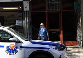 Un vehículo de la Ertzaintza frente al portal donde residía el fallecido hallado axfisiado en Irun.