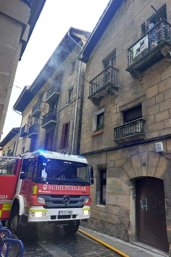 Una dotación de bomberos y humo en el lugar del incendio.