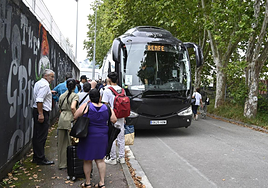 Pasajeros se suben a un bus habilitado por Renfe durante el corte del verano anterior.