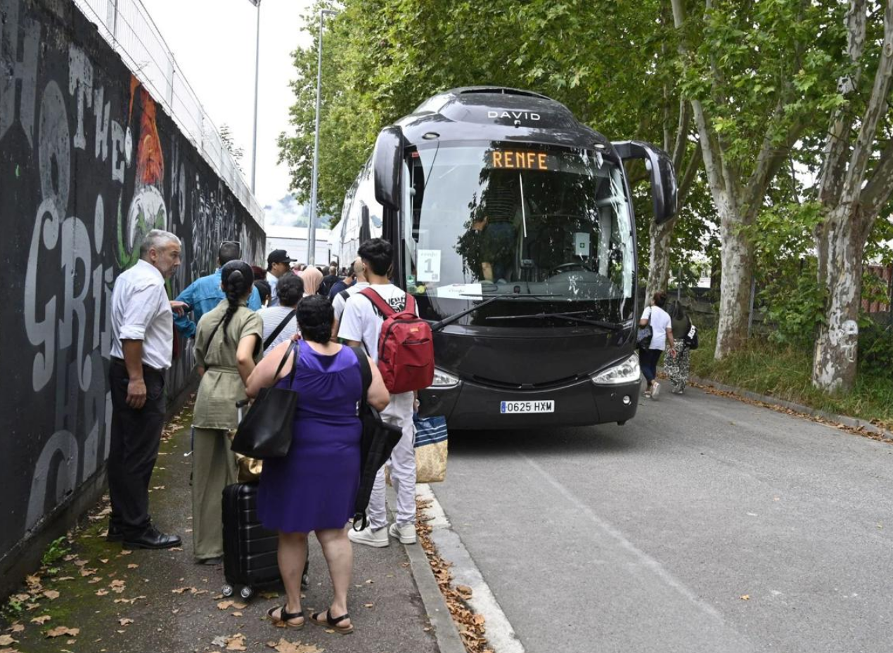 Pasajeros se suben a un bus habilitado por Renfe durante el corte del verano anterior.