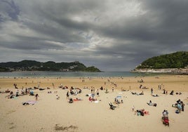 La buena temperatura ha animado a muchos a acercarse a la Playa de La Concha, pese a las nubes.