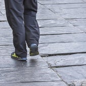 Un viandante esquiva una de las baldosas de pizarra hundidas en la plaza del Triángulo.