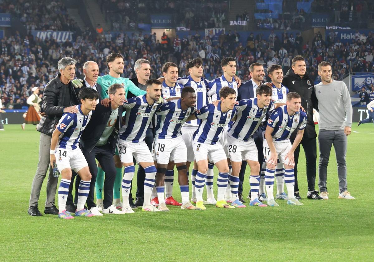 Los cuatro homenajeados con el once inicial de la Real.