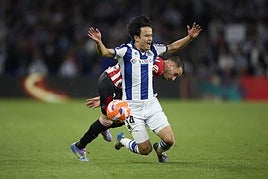 Take Kubo es derribado por Berengue en un lance del derbi de Anoeta