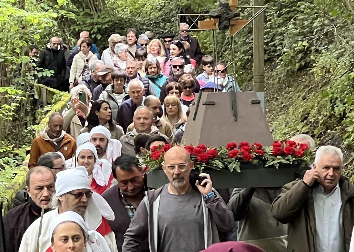 La Cruz, custodiada por ezpata dantzaris, txistularis y fieles en el kilómetro y medio de camino desde la parroquia hasta Mirandaola.