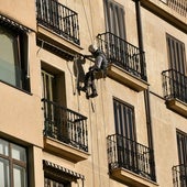 Un empleado trabaja en la reforma de una fachada.