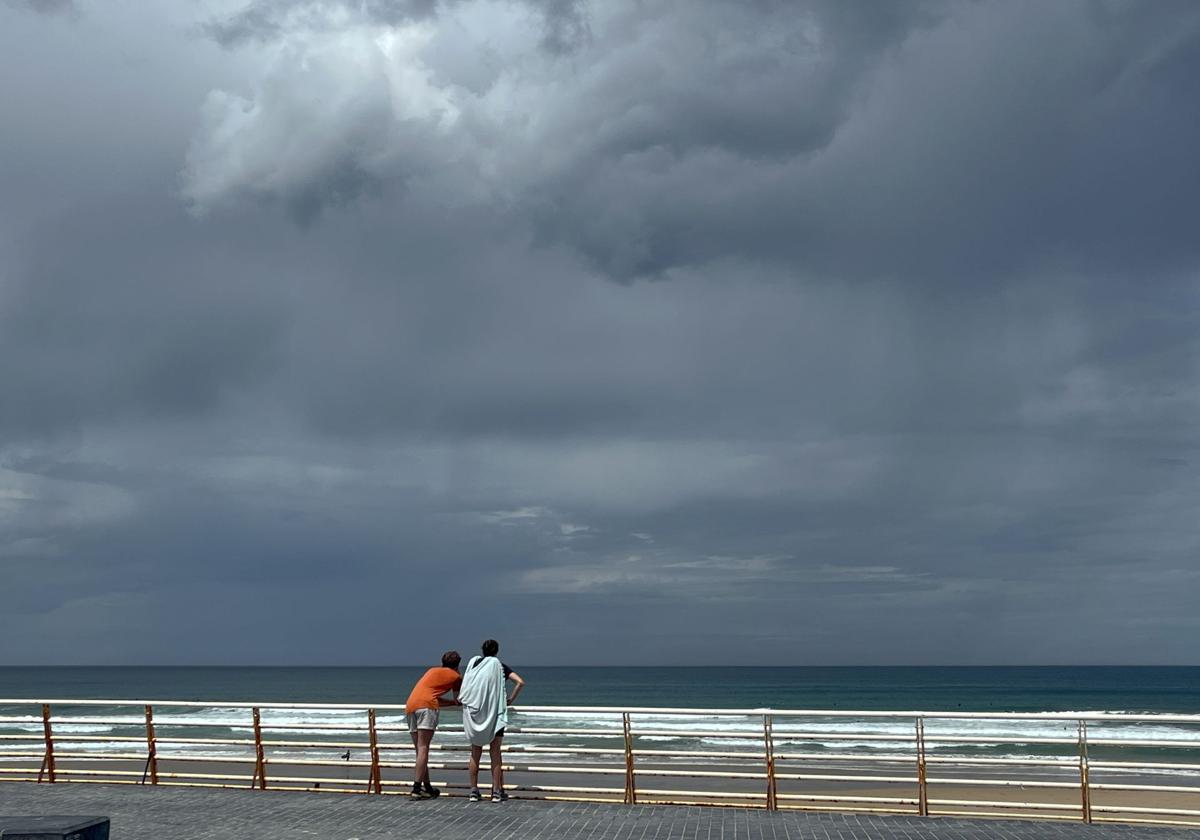 Una pareja observa el cielo y el mar ayer en el Paseo de Zurriola, en San Sebastián.