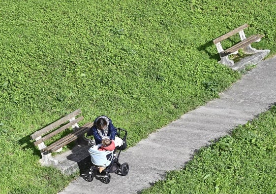 Una mujer atiende a su hijo en un parque de Usurbil.