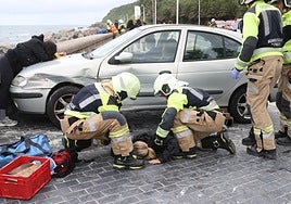Varios bomberos rescatan a una de las heridas en el simulacro llevado a cabo este jueves en Donostia.