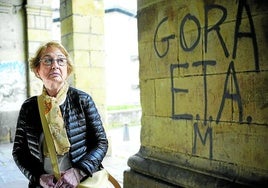 Carmen Hernández, viuda de Jesús Mari Pedrosa, en los soportales de la iglesia de Santa Ana en Durango, junto a una pintada de apoyo a ETA.