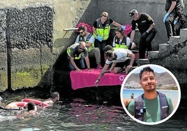 Sanitarios y agentes policiales ayudan a que varios migrantes naden y alcancen el puerto de El Hierro y Francisco Navarro en una playa de Tenerife.