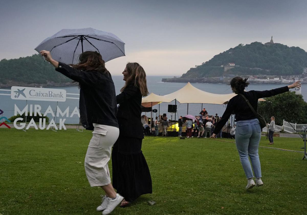 Varias jóvenes bailan bajo la lluvia y la tormenta ayer en Donostia