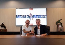 Griezmann estrecha la mano de Gil Martín para escenificar el acuerdo para la renovación de su contrato hasta 2027