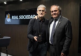 oberto Olabe muestra la insignia de oro y brillantes de la Real, este lunes junto a Jokin Aperribay en el auditorio del Reale Arena.