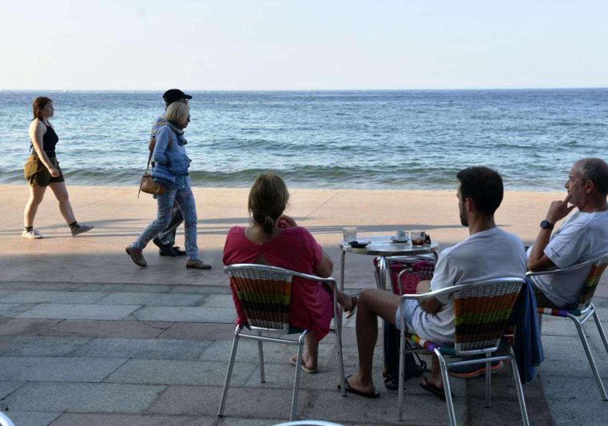 Transeúntes pasean por el malecón de Zarautz.