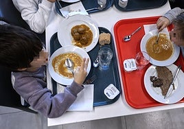 Dos niños comen en una jangela.