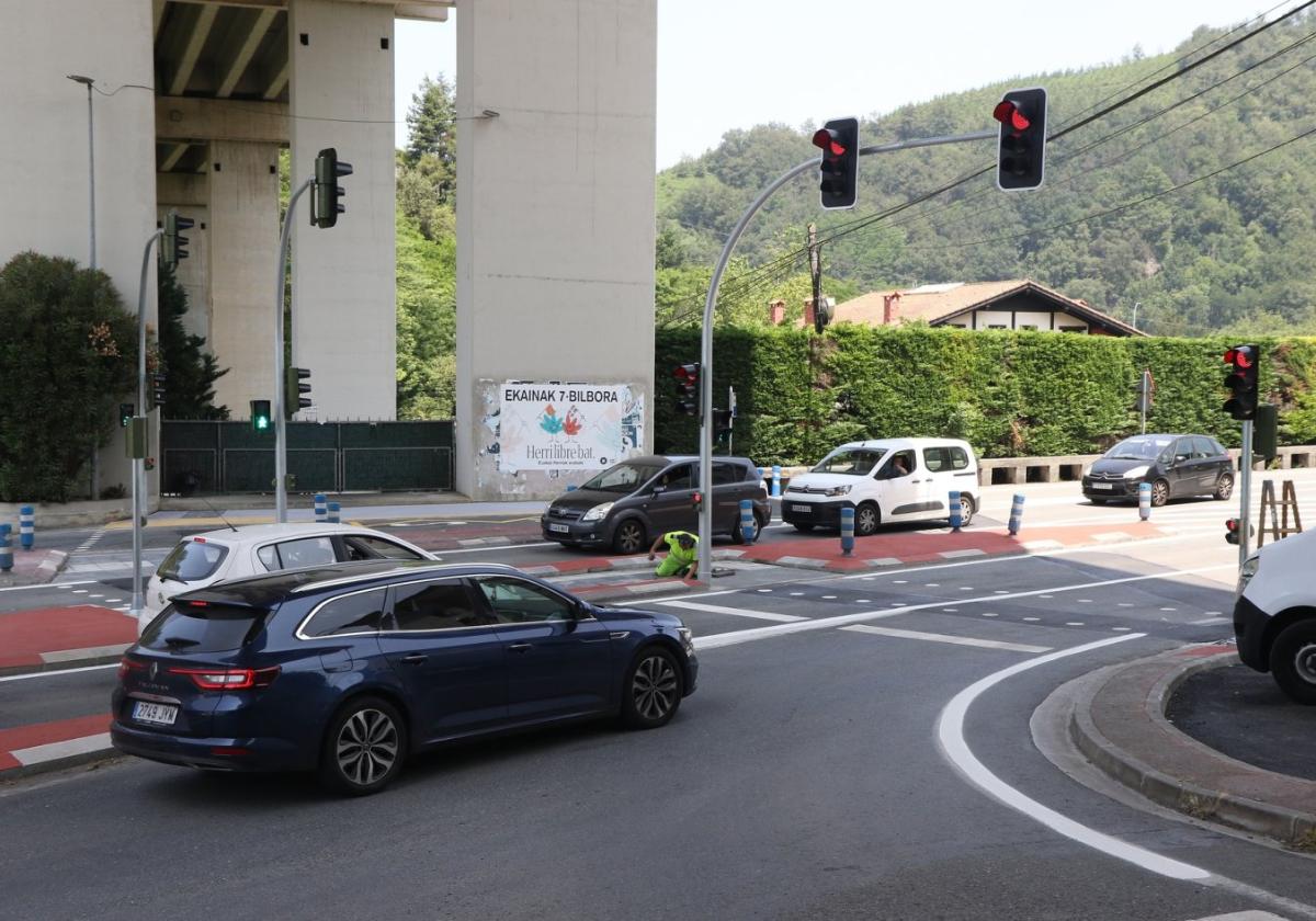 Vehículos parados en el nuevo paso peatonal de Usatorre, con un operario terminando la puesta a punto.