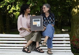 Ainara Martín y Usoa Zumeta sostienen un cuaderno que contienen dibujos de Koldobika Jauregi.
