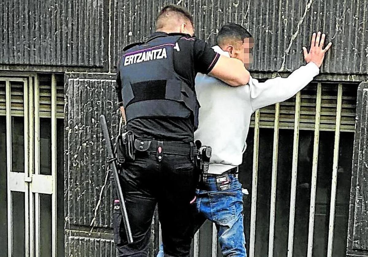Un ertzaina registra a un sospechoso.
