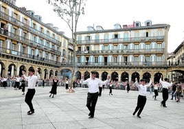 Eneko Goia, con el simbólico aro de mimbre en su mano derecha, baila junto a otros corporativos ante el fresno en llamas, este lunes en la plaza de la Constitución.