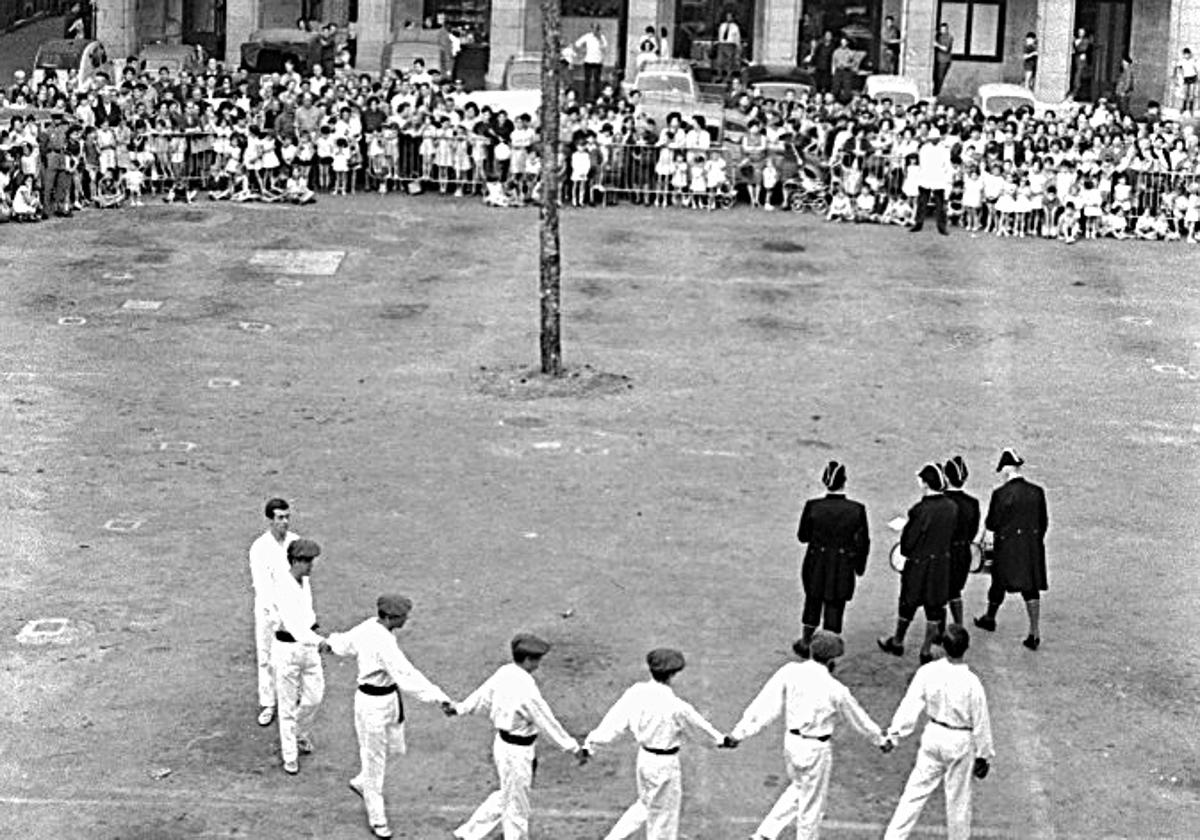 El tradicional baile del árbol de San Juan. Obsérvese que quedan automóviles estacionados al fondo.