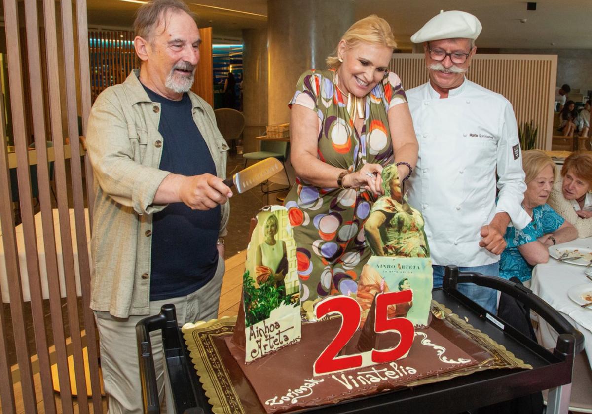 Manolo Herrero, presidente de Vinatelia, y la soprano Ainhoa Arteta cortan la tarta del 25 aniversario de la entidad ante la atenta mirada del pastelero Rafa Gorrotxategi.