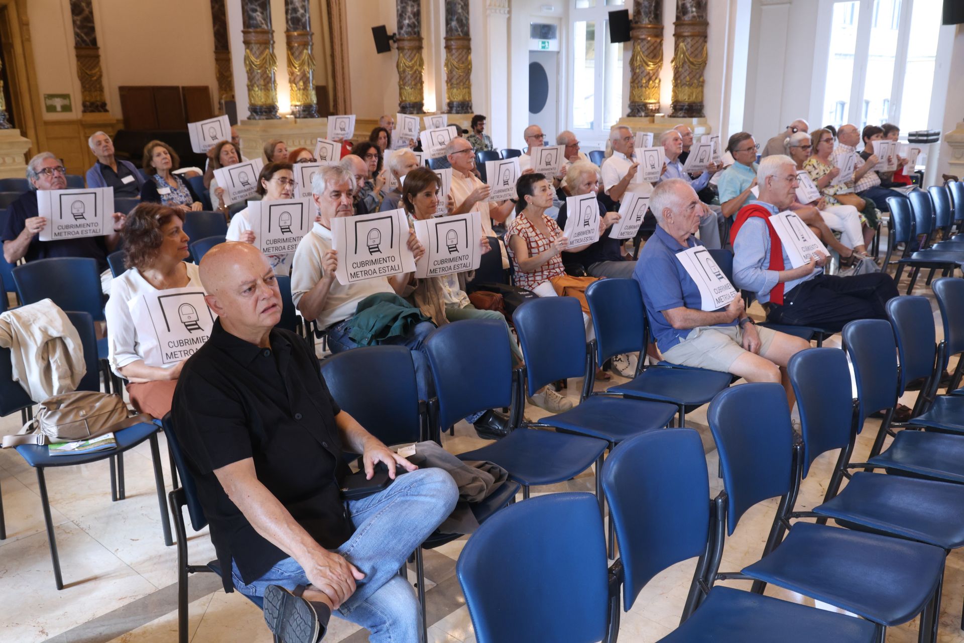 Vecinos de Amara, detrás de Odón Elorza, muestran carteles en favor del cubrimiento de las vías del Topo.