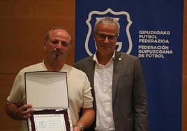 Enrike Lekuona con la placa entregada por Manu Díaz.