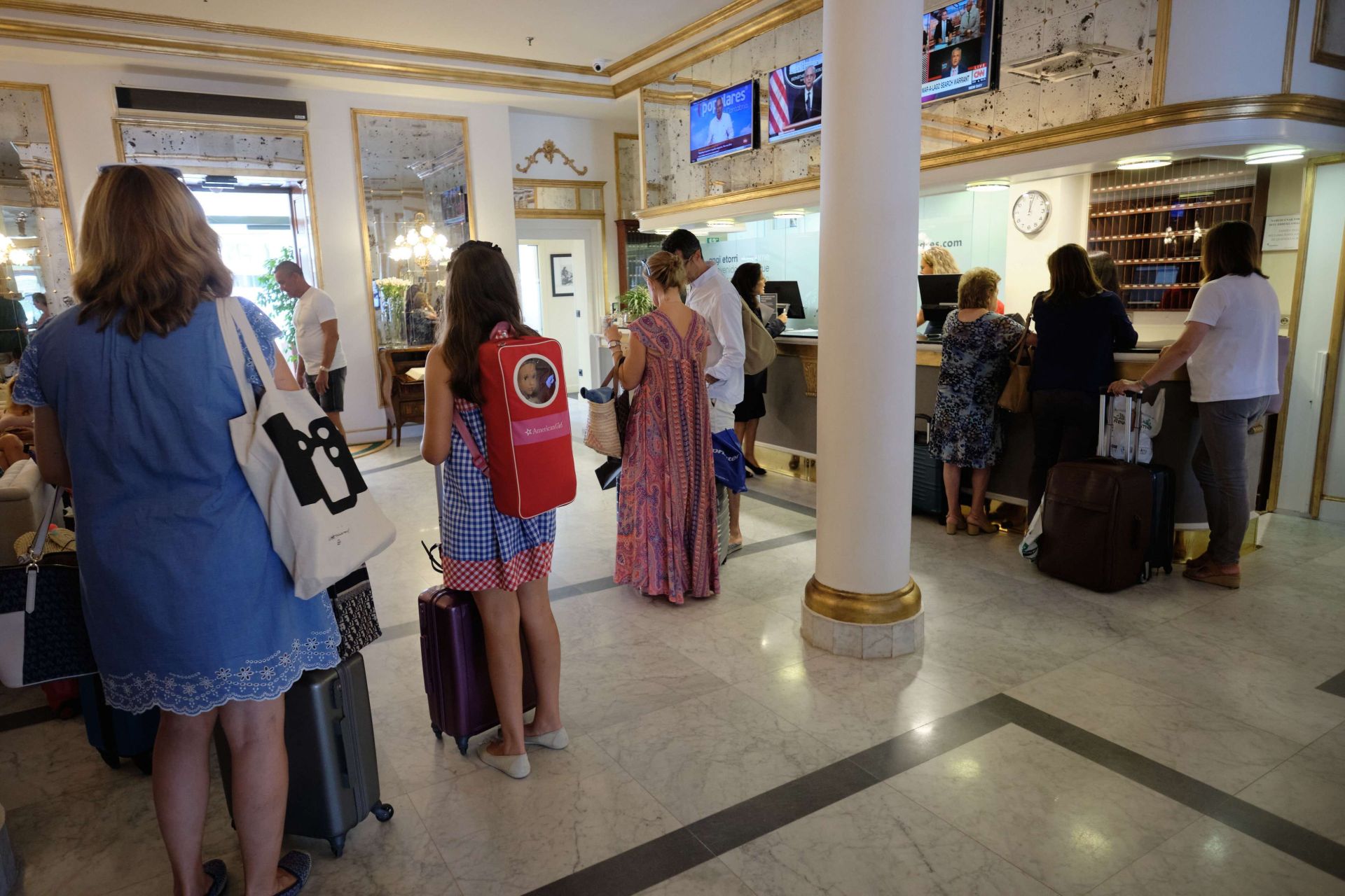 Varios turistas aguardan la vez ante la recepción de un hotel donostiarra.