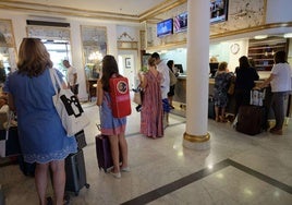 Varios turistas aguardan la vez ante la recepción de un hotel donostiarra.