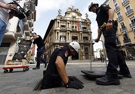 Agentes de la Policía Nacional inspeccionan las galerías subterráneas bajo el recorrido del encierro.