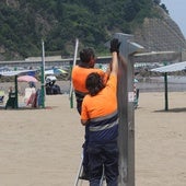 Operarios realizan unos ajustes en las duchas de la playa de Santiago, el pasado verano.