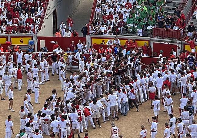 La gente espera desde la arena a la salida de una de las vaquillas.