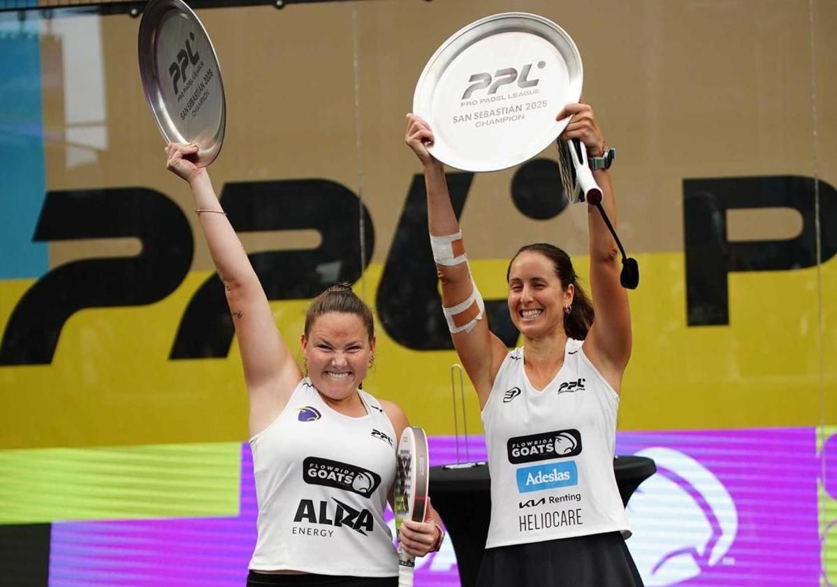 La pareja levanta el título que les proclama campeonas del torneo.