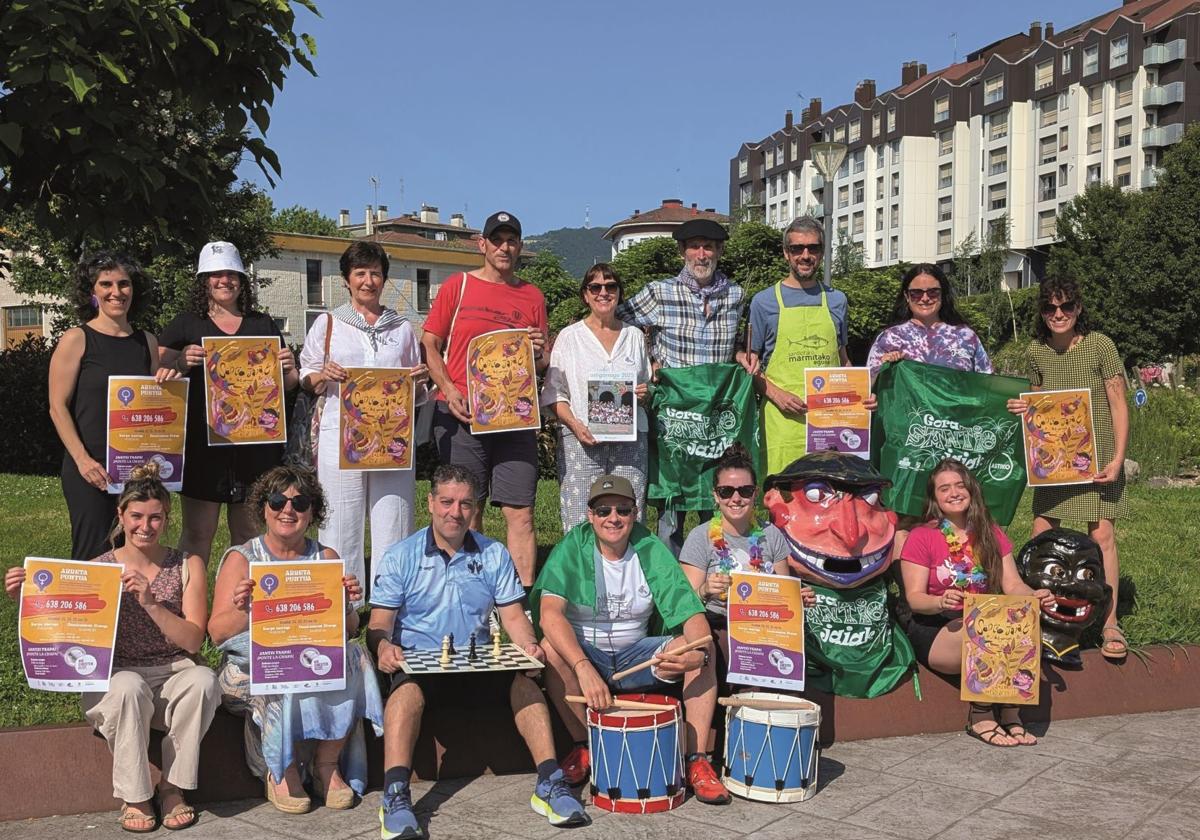 Miembros de Jai Batzordea con el cartel de las fiestas.