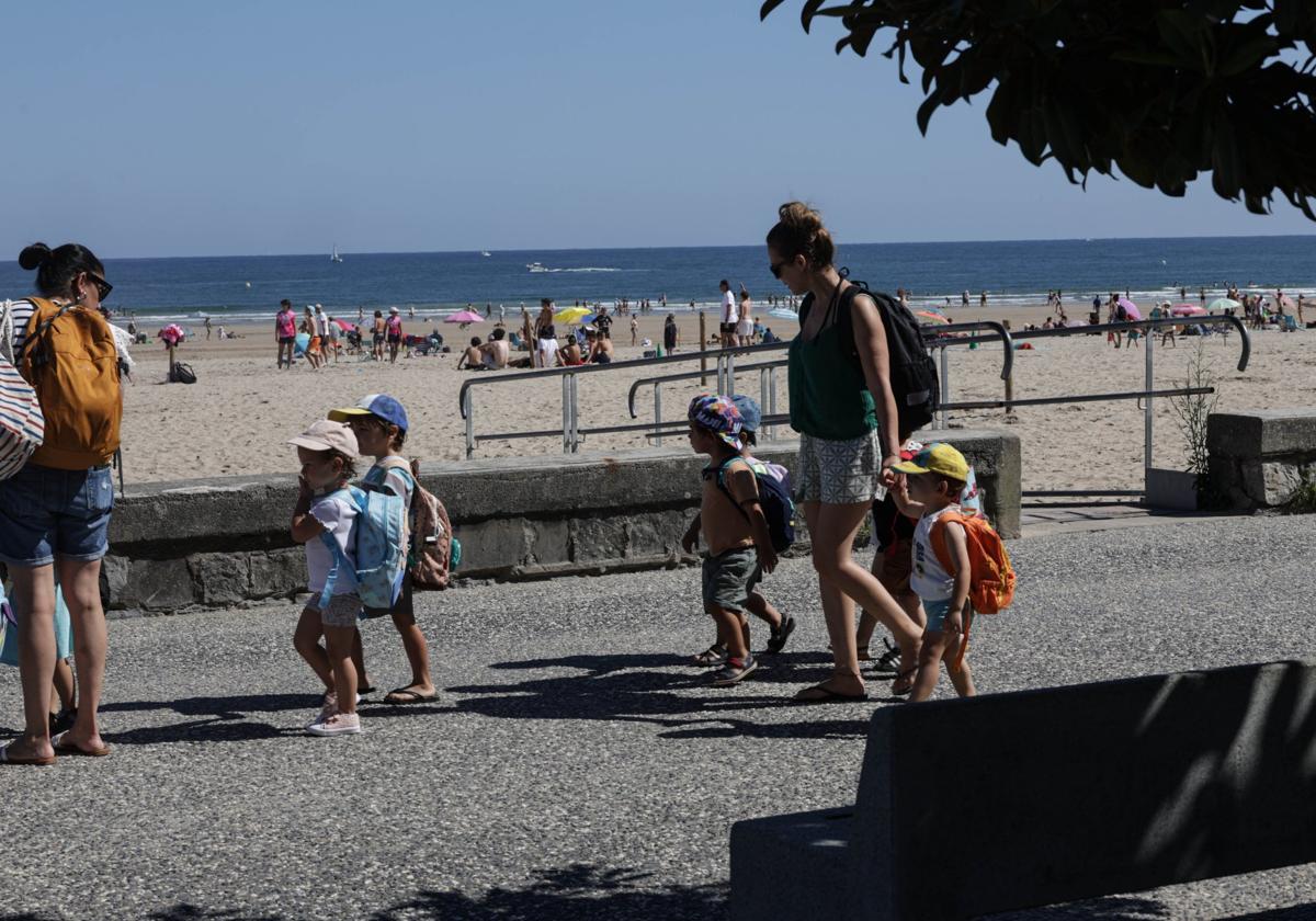 Una monitora pasea con varios niños por Hendaia.