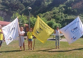 Andoni Campos, Anuska Esnal, Itziar Olasagasti, Olatz Santamaria eta Lourdes Salsamendi, atzo eguerdian Orioko kanpiñean asteburu honetan Orion jokoan izango diren hiru banderak erakutsiz.