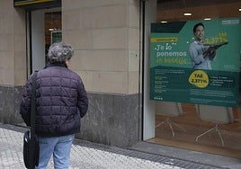 Un hombre se fija en una oferta de hipotecas en una entidad bancaria de Donostia.