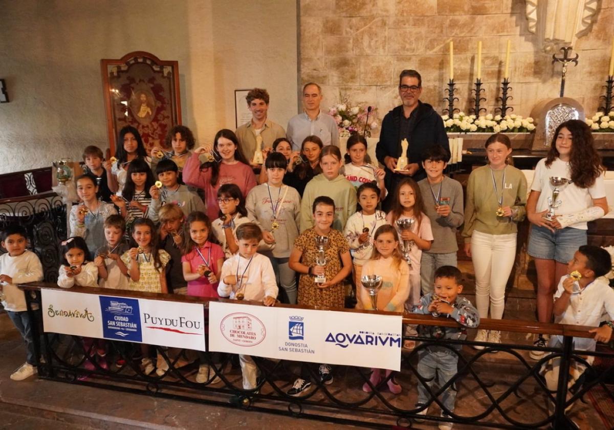 Las niñas y niños premiados posan con sus trofeos junto al alcalde Eneko Goia, el concejal de Cultura Jon Insausti y Javier Ganuza, uno de los organizadores del evento.